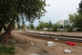 Budowa linii tramwajowej w ulicy Wilczyńskiego, między ulicą Wachowskiego a przyszłym przystankiem końcowym Pieczewo (1 lipca 2022) - pierwsze zespawane już szyny w śladzie torowiska czekają na umocowanie